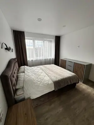 a bedroom with a large bed and a window at Lauros Apartamentai in Kupiškis