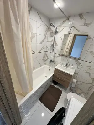 a bathroom with a tub and a toilet and a sink at Lauros Apartamentai in Kupiškis