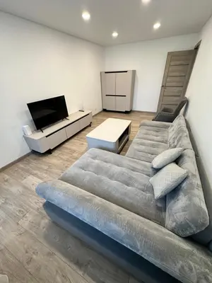 a living room with a couch and a flat screen tv at Lauros Apartamentai in Kupiškis