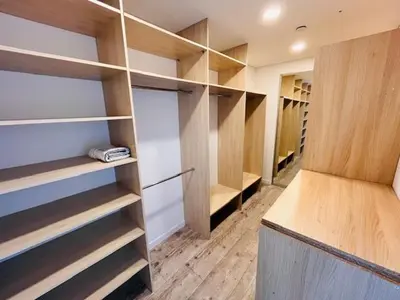 a walk in closet with wooden shelves and cabinets at Menulio Misko Nights in Vilkija