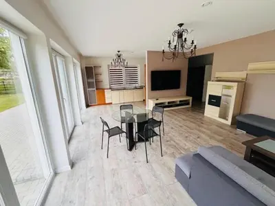 a living room with a glass table and chairs at Menulio Misko Nights in Vilkija