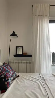 a bedroom with a bed and a lamp and a window at Kalinovs Stay Apartment in Adutiškis