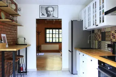 a kitchen with white cabinets and a black refrigerator at Secluded private villa in the middle of the woods in Margionys