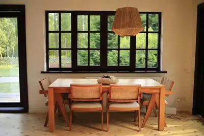 a dining room table with chairs and aendant light at Secluded private villa in the middle of the woods in Margionys