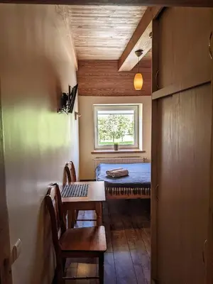 a room with a bed and a table and a window at Guest House Kamara in Panevėžys