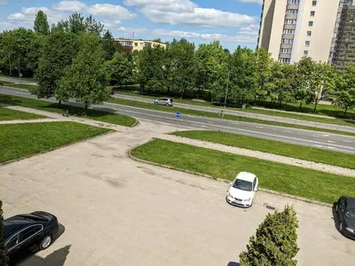 a white car parked in a parking lot next to a street at Guest House Kamara in Panevėžys
