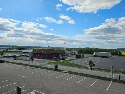 an empty parking lot with a truck and a building at ----------------------------- Via Baltica Panevezys in Panevėžys