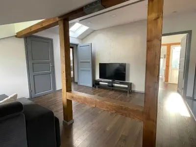 a living room with a flat screen tv and wooden beams at newTown in Kaunas