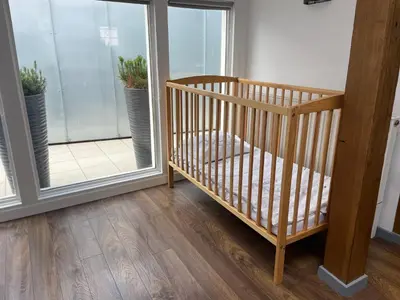 a wooden crib in a room with a window at newTown in Kaunas