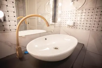 a white sink in a bathroom with a mirror at Hostel K3a in Vilnius