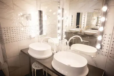 a bathroom with two sinks and two mirrors at Hostel K3a in Vilnius