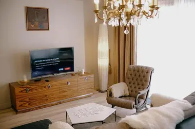 a living room with a tv on a wooden entertainment center at Central apartment in Gaono residence in Vilnius