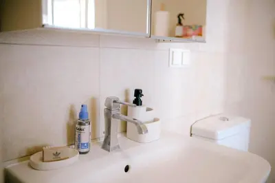 a white bathroom with a sink and a toilet at Central apartment in Gaono residence in Vilnius