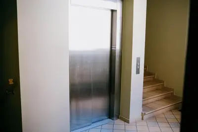 a glass door leading to a hallway with stairs at Central apartment in Gaono residence in Vilnius
