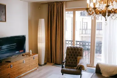 a living room with a chair and a television at Central apartment in Gaono residence in Vilnius