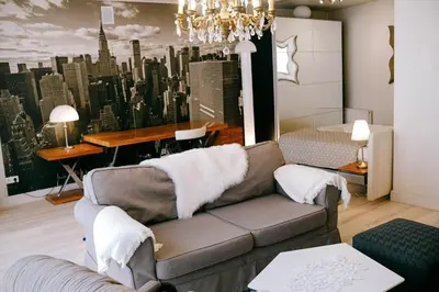a living room with a couch and a city mural at Central apartment in Gaono residence in Vilnius