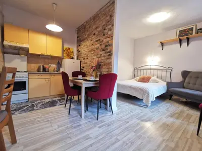 a kitchen and a bedroom with a table and chairs at Apartment in Heart of Užupis - perfect location in Vilnius