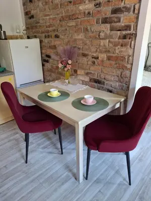 a table with two plates and red chairs at Apartment in Heart of Užupis - perfect location in Vilnius