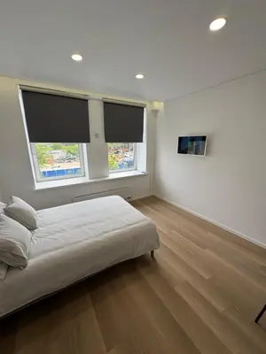 a white bedroom with a bed and two windows at 5 New Airport Apartment in VNO
