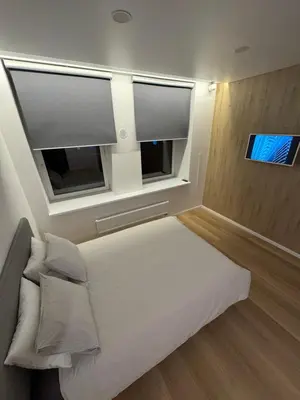 a bedroom with a bed and two windows at 6 New Airport Apartment in VNO