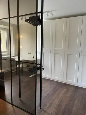 a room with white cabinets and a glass wall at Centro apartamentai in Biržai