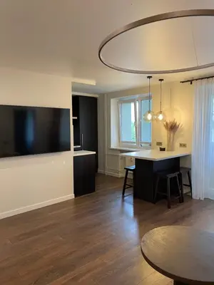 a living room with a table and a tv at Centro apartamentai in Biržai