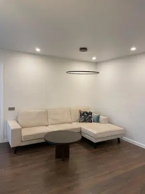 a white living room with a couch and a table at Centro apartamentai in Biržai