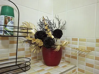 a red vase with flowers on a shelf in a bathroom at Cozy Studio in Vilnius Old Town in Vilnius