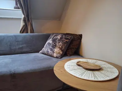 a table with a hat on top of a couch at Cozy Studio in Vilnius Old Town in Vilnius