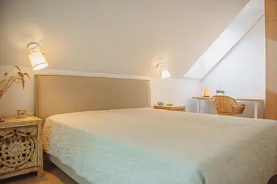 a bedroom with a white bed and a chair at Oak Zen Home in Birštonas