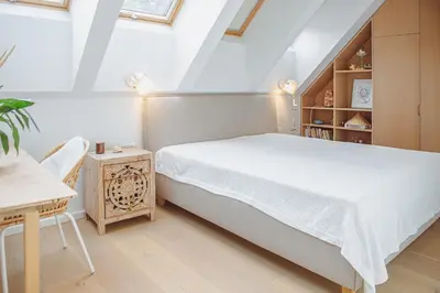 a bedroom with a white bed and a wooden cabinet at Oak Zen Home in Birštonas