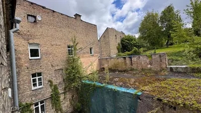 an old brick building with a fence in front of it at Cozy stay Vilnius in Vilnius
