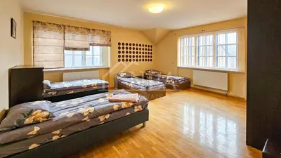 a room with three beds and a couch in it at Guest house Sunrise in Šiauliai