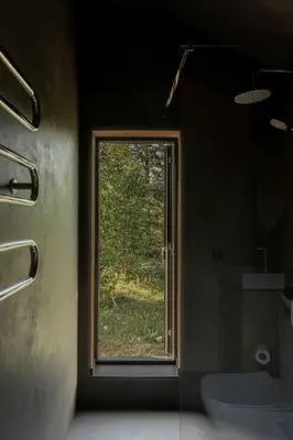a bathroom with a window and a toilet in a room at Getlost cabins in Valanciunai