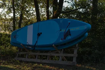 a blue surfboard sitting on top of a stand at Getlost cabins in Valanciunai