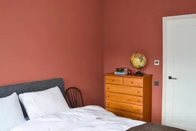 a bedroom with a bed and a wooden dresser at Getlost cabins in Valanciunai
