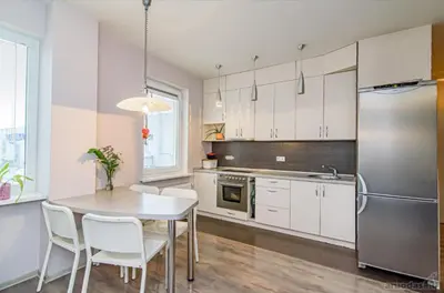 a kitchen with a table and chairs and a refrigerator at Apartment Beauty in Vilnius