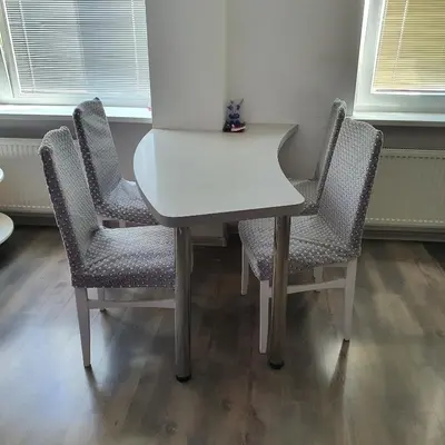 a white table with four chairs in a room at Apartment Beauty in Vilnius