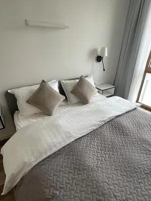 a bedroom with a bed with white sheets and pillows at Flat in central of Vilnius in Vilnius