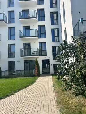 a white building with a brick walkway in front of it at Flat in central of Vilnius in Vilnius