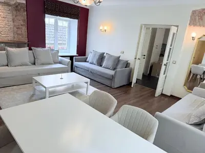 a living room with couches and a table and chairs at Pilies8 Luxury Vilnius Apartment in Vilnius