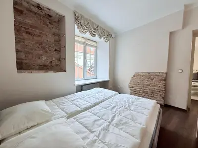a bedroom with a large bed and a brick wall at Pilies8 Luxury Vilnius Apartment in Vilnius