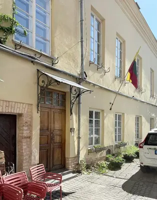 a building with a flag and chairs in front of it at Pilies8 Luxury Vilnius Apartment in Vilnius