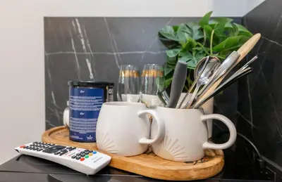a table with two coffee cups and a remote control at Trumpalaikė butų nuoma Kaune prie Klinikų MINIUKAS SELF CHECK-IN in Kaunas