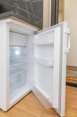 an empty refrigerator with its door open in a kitchen at Trumpalaikė butų nuoma Kaune prie Klinikų MINIUKAS SELF CHECK-IN in Kaunas