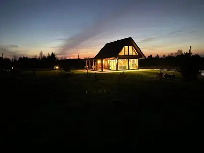a house lit up at night in a field at 12 Bijūnų in Joniškis