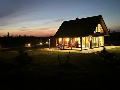 a house lit up at night in a field at 12 Bijūnų in Joniškis