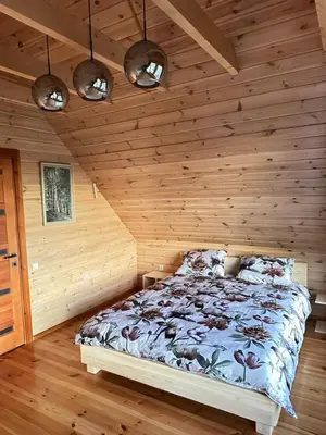 a bedroom with a bed in a wooden room at 12 Bijūnų in Joniškis