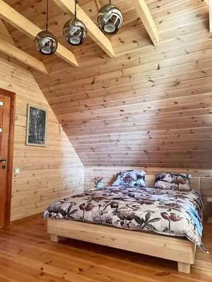 a bedroom with wooden walls and a bed in a room at 12 Bijūnų in Joniškis
