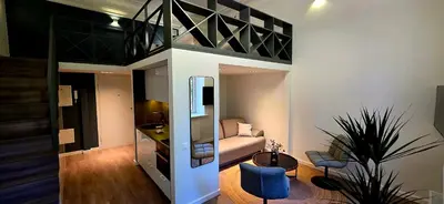 a room with a loft bed with a couch at Telegrafas25-modern apartment in the center of Kaunas in Kaunas
